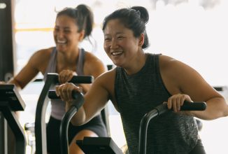 Lady on exercise bike smiling while pedalling
