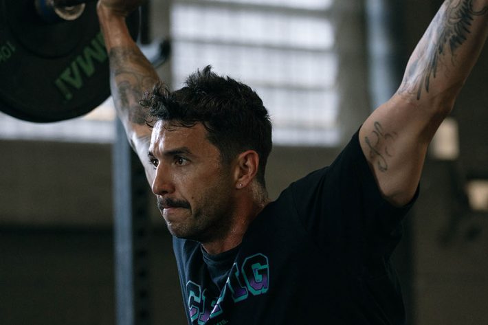 Man lifting loaded barbell over his head